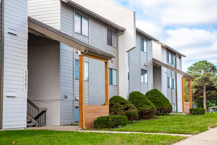 a street view of a building with a porch and a sidewalk