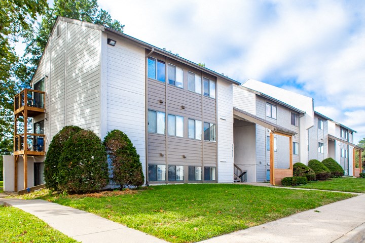 an apartment building with a sidewalk in front of it