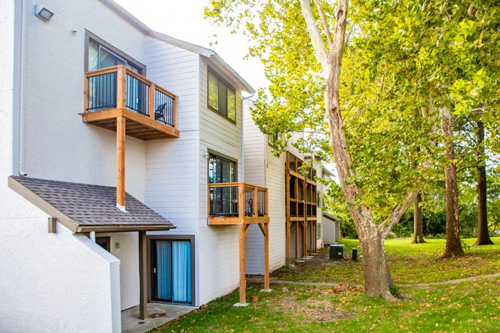 the back of a house with a tree in the yard