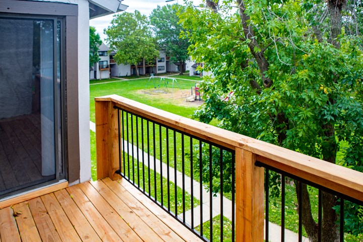 a deck with a view of a yard and trees