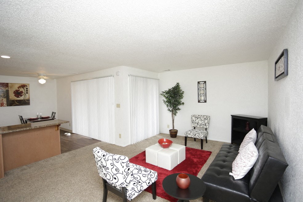 a living room with a black leather couch and a coffee table