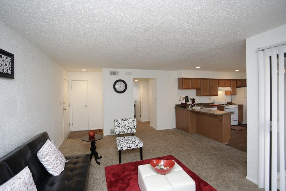 a living room and kitchen with a couch and a table