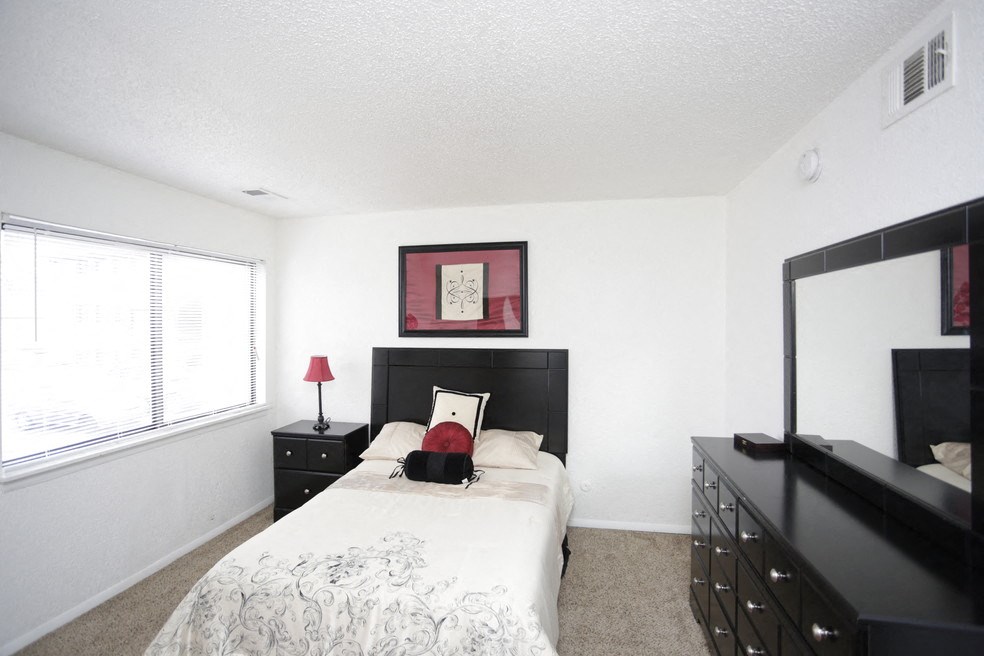 a bedroom with a bed and a dresser and a window