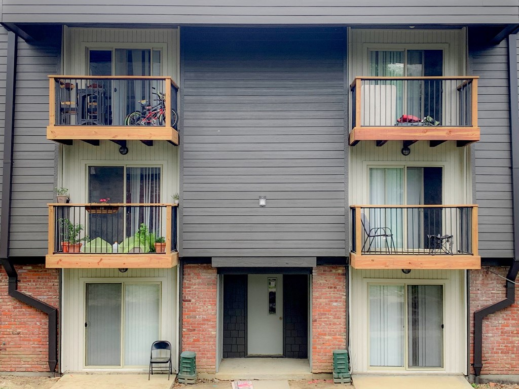 a row of apartments with balconies and chairs