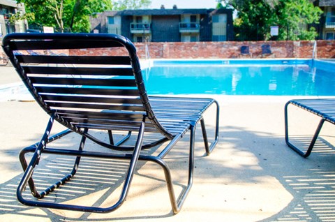 a lounge chair next to a swimming pool