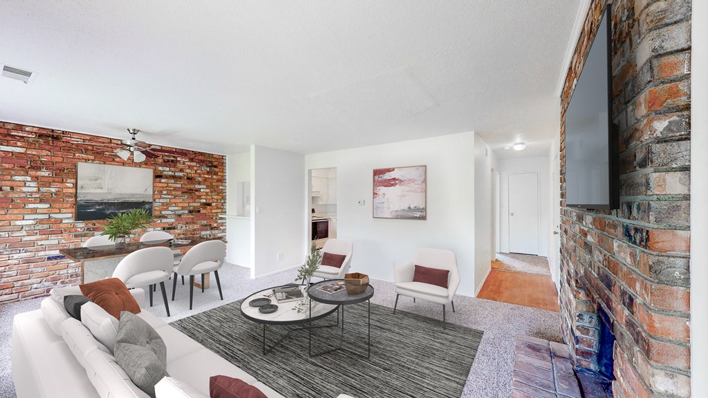 a living room with a couch and a table and a brick wall