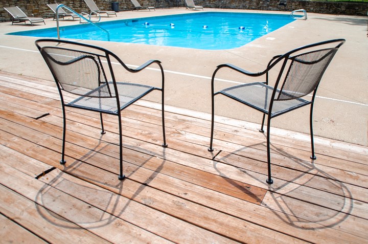 a pair of chairs sitting next to a pool