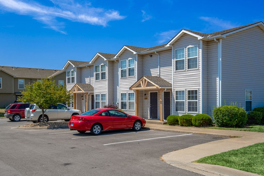 a red car parked in front of an apartment building