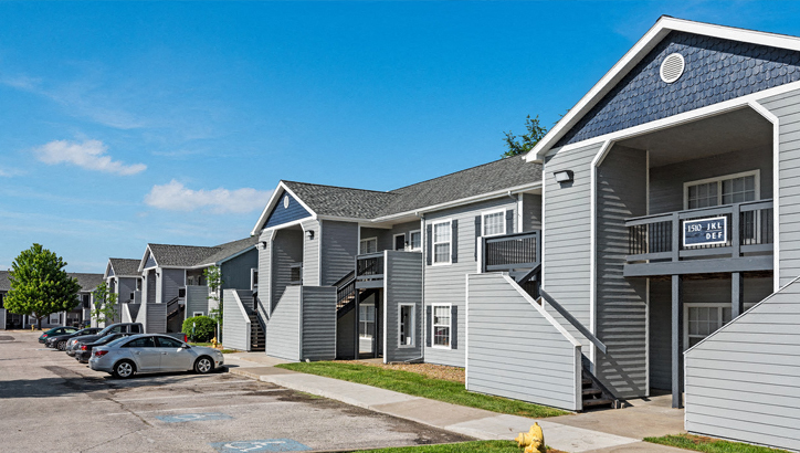 a row of houses with cars parked in front of them