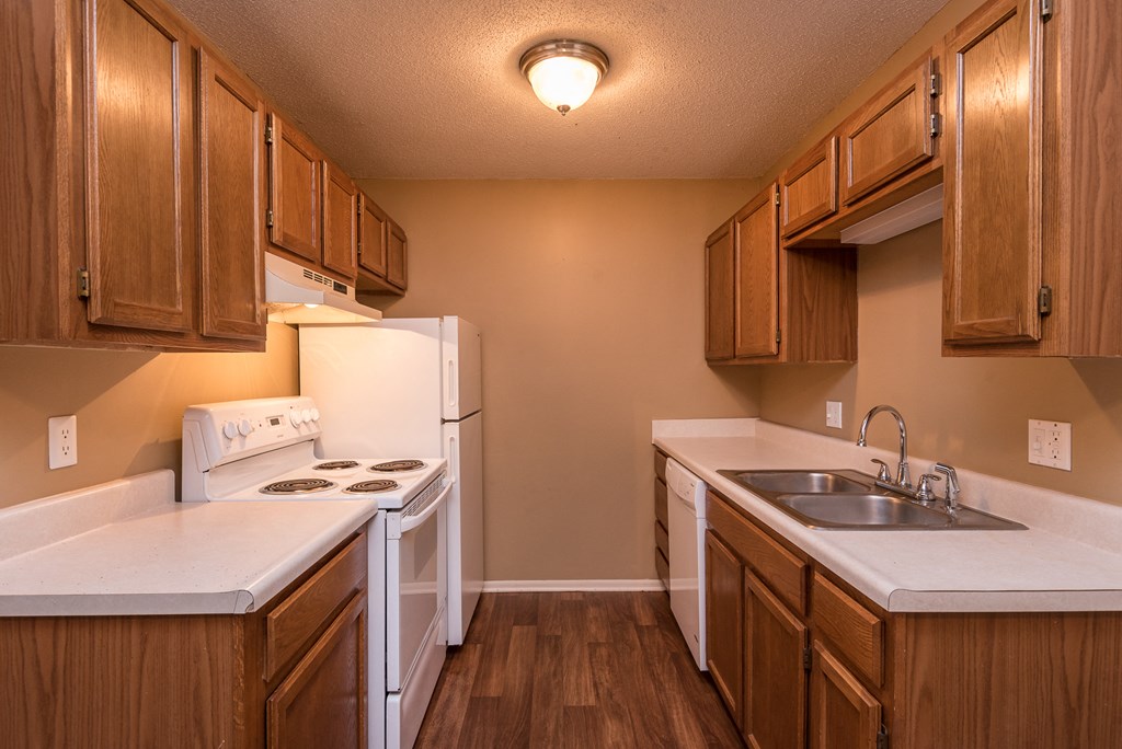 a kitchen with white appliances and wooden cabinets