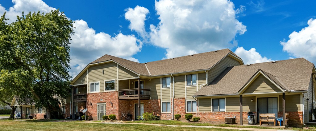 the view of an apartment building with brick and tan siding