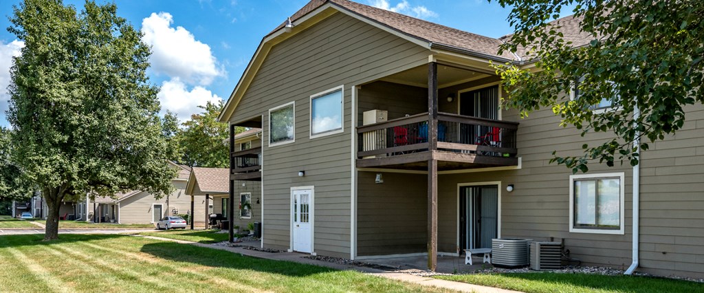 the back of a house with a porch and a tree