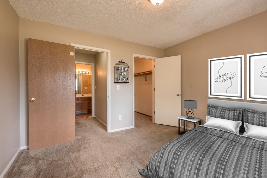 a bedroom with a bed and a closet and a bathroom