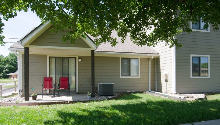 a house with two red chairs on the front porch