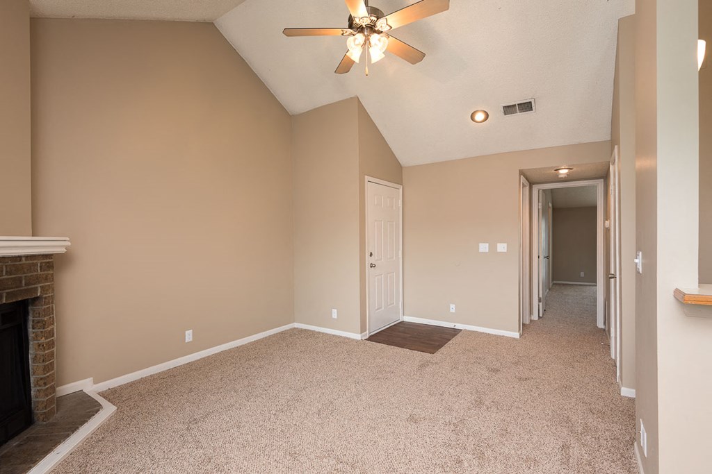 a empty living room with a ceiling fan