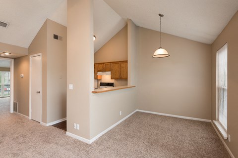a spacious living room with carpeted floors and a large window