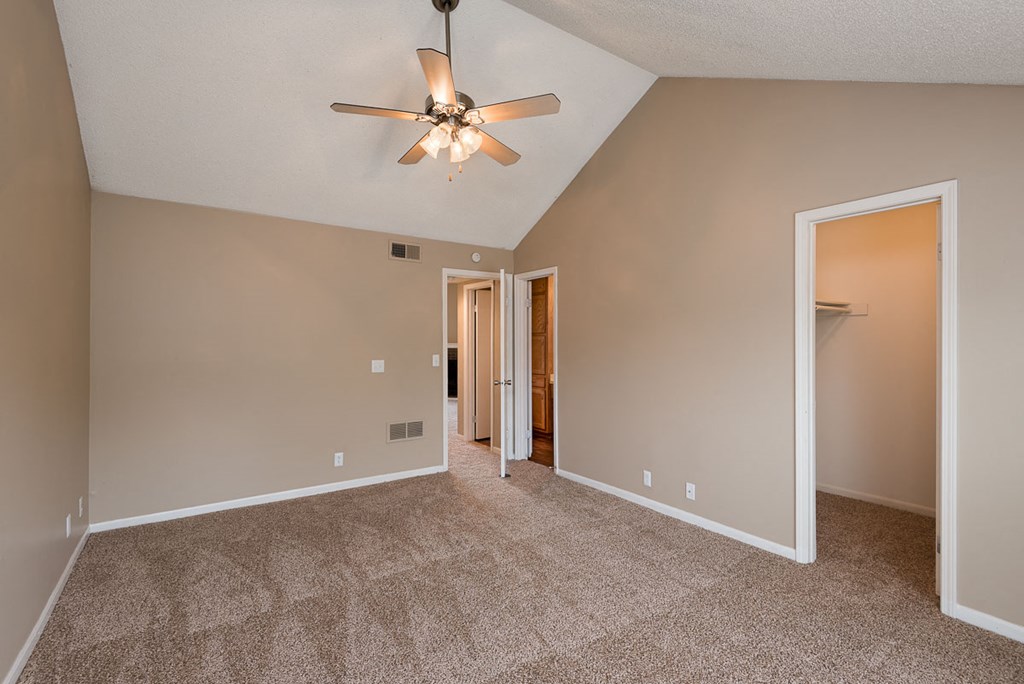 a empty living room with a ceiling fan