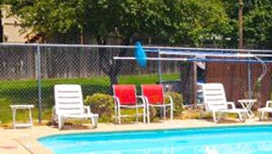a swimming pool with red chairs around it