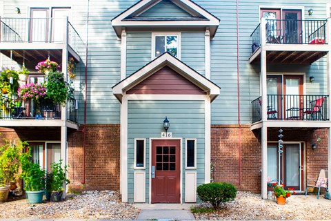 the front of a blue house with a red door