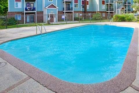 a large blue swimming pool in front of an apartment building