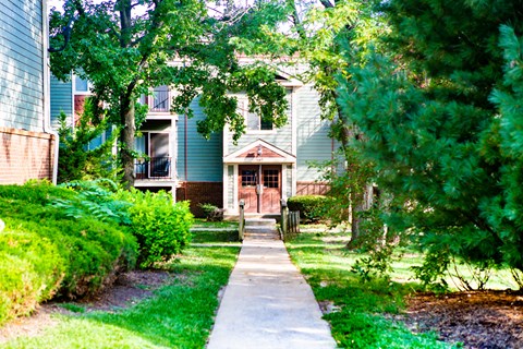 a sidewalk in front of a blue house