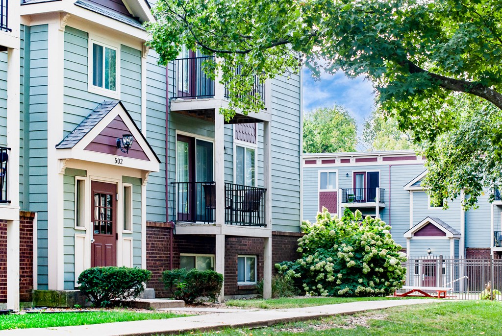 a row of apartments with a sidewalk in front of them