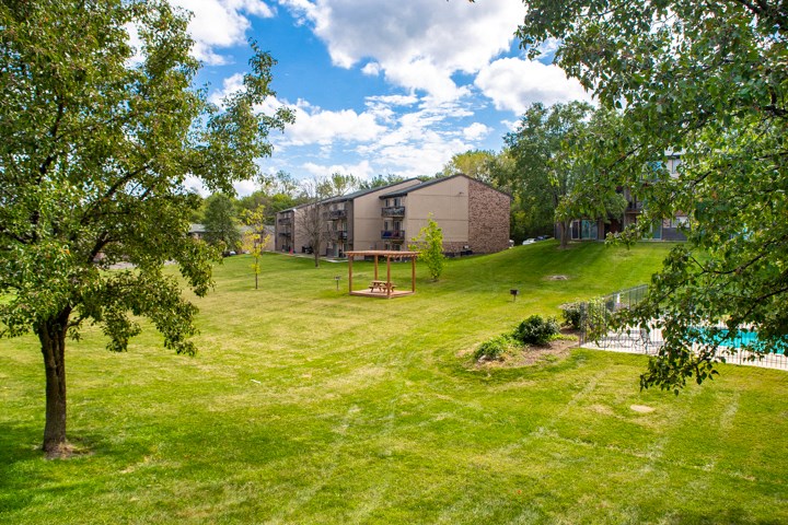 a yard with a swing set in front of a building
