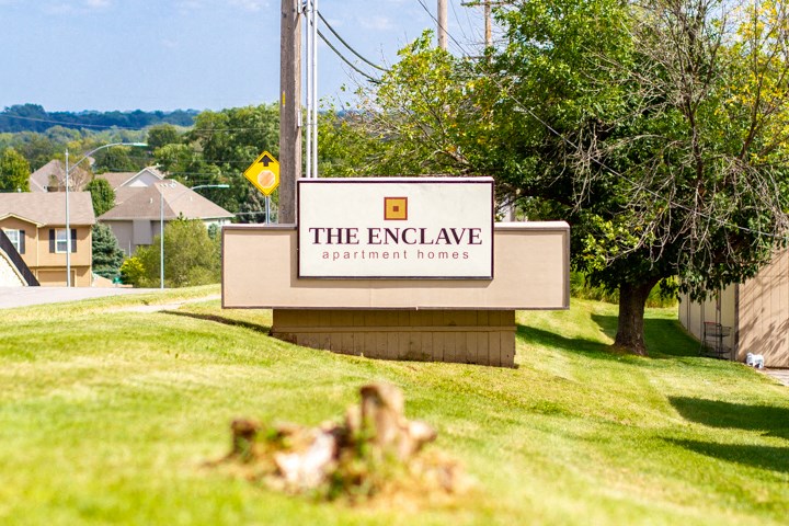the enclave apartment homes sign on the side of the street