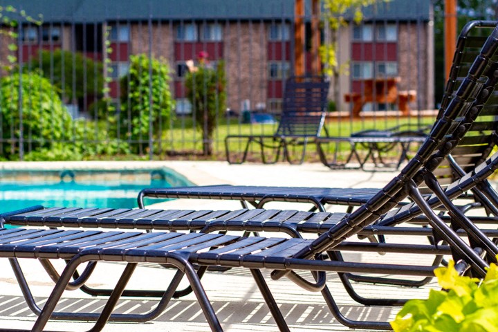 a group of lounge chairs next to a swimming pool