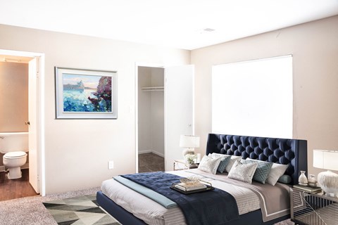 a bedroom with a bed and a bathroom with a toilet