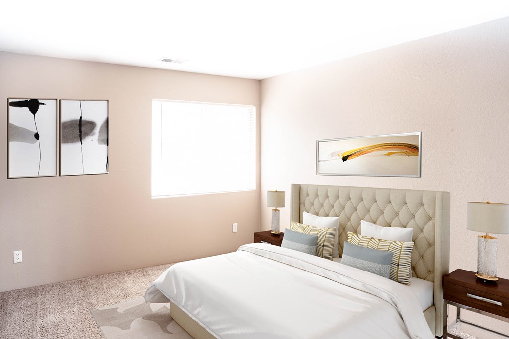 a bedroom with a white bed and pillows and a window