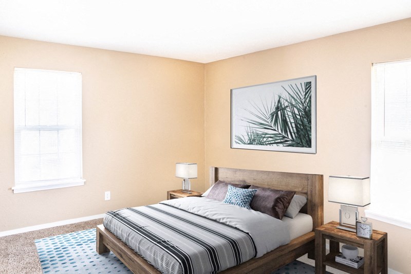 a bedroom with a bed and two windows