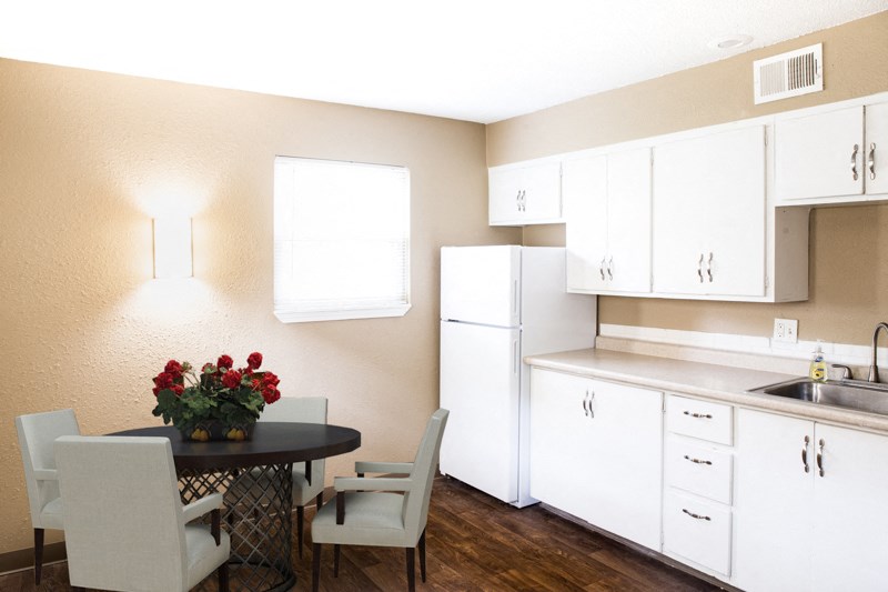 a kitchen with white cabinets and a table with chairs