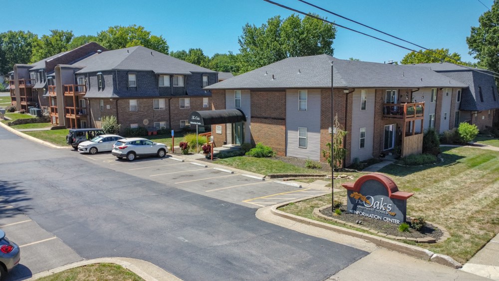 an aerial view of an apartment complex with cars parked in a parking lot
