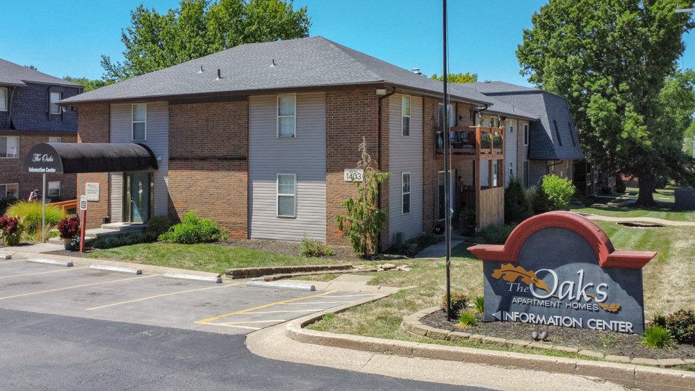 the apartments sign in front of a brick apartment building