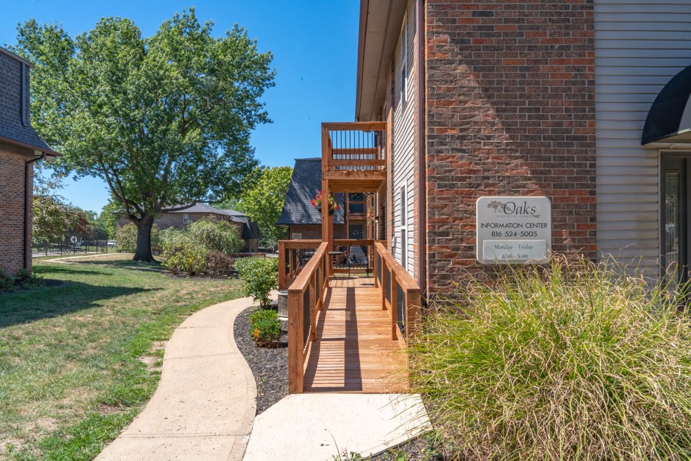 the front porch of a brick building with a wooden deck
