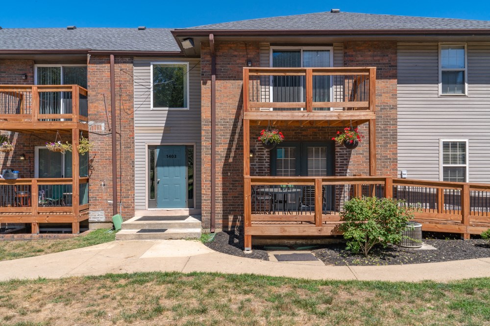 the front of a house with two decks and a blue door