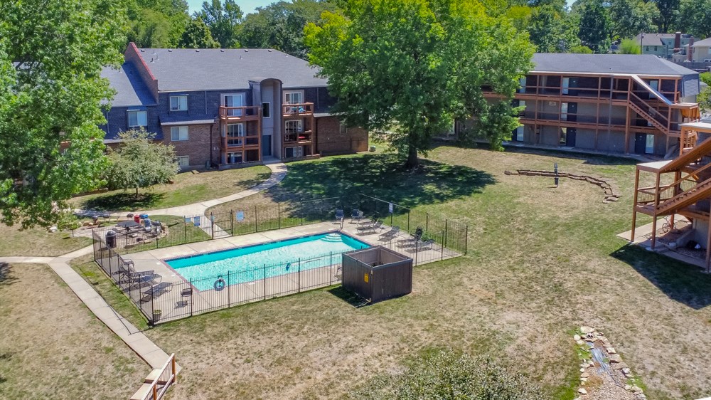 an aerial view of a swimming pool in the yard of an apartment building