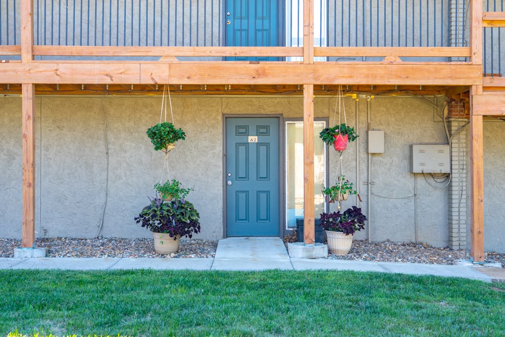 the front of a building with a blue door and potted plants