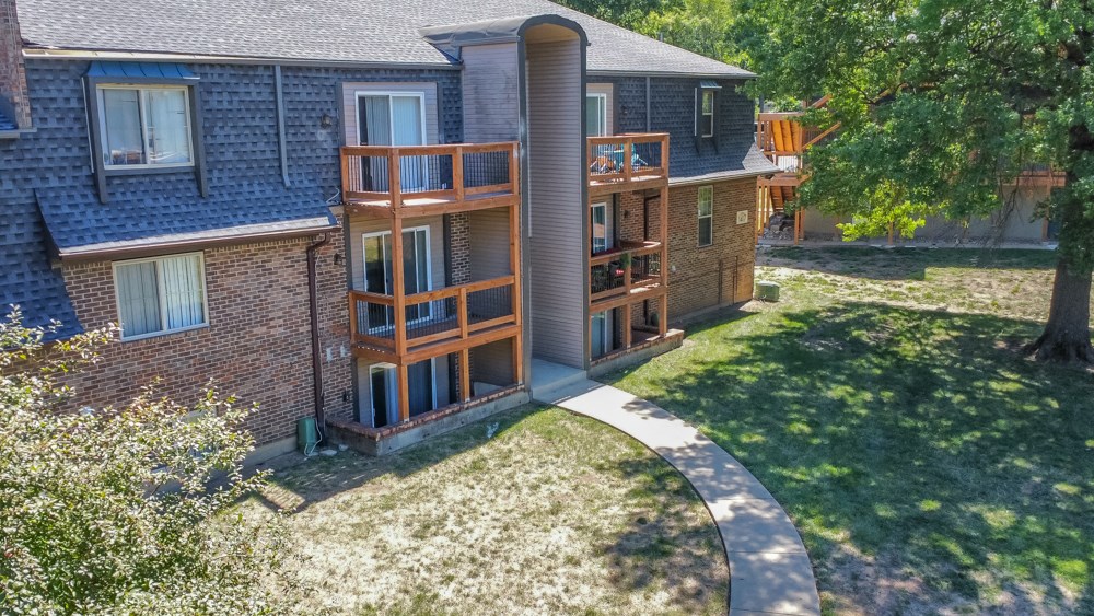 a walkway leading to a brick house with wooden balconies