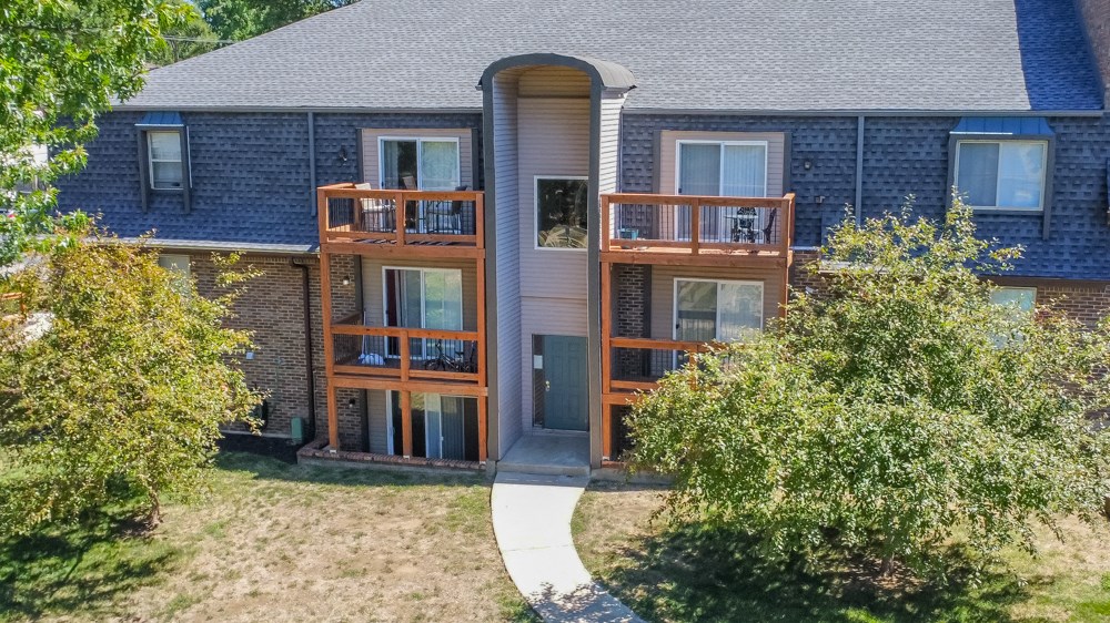 the back of a house with a sidewalk in front of it