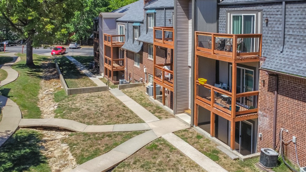 an aerial view of a row of apartment buildings on a sidewalk
