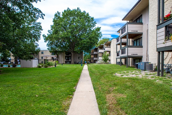the grassy area between two apartment buildings on a sunny day