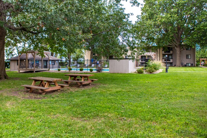a picnic area with benches in the grass