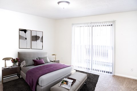 a bedroom with a bed and a large window