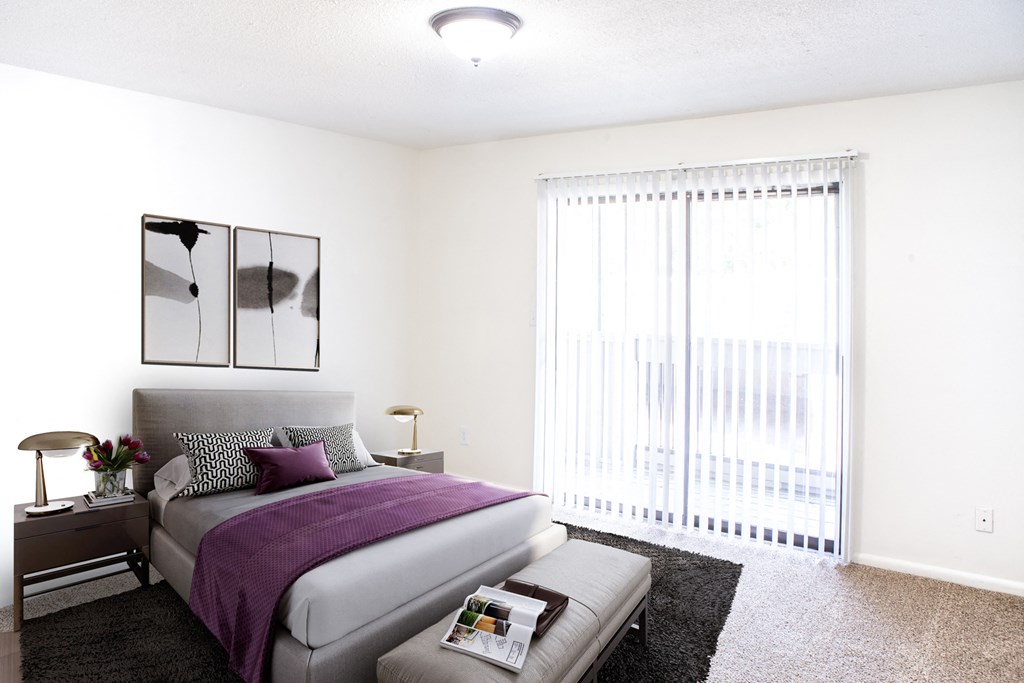 a bedroom with a bed and a large window