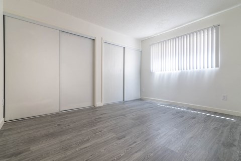 an empty living room with white walls and wood flooring