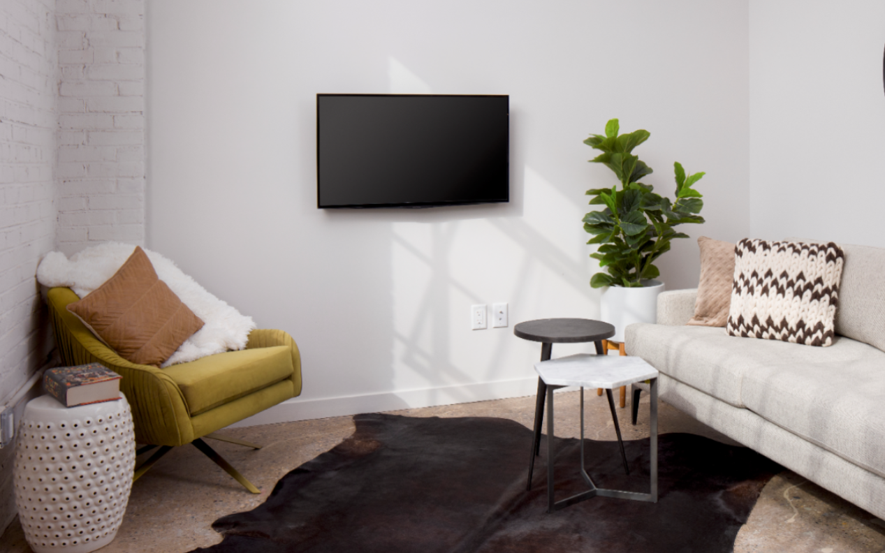 a living room with a couch and a tv on the wall
