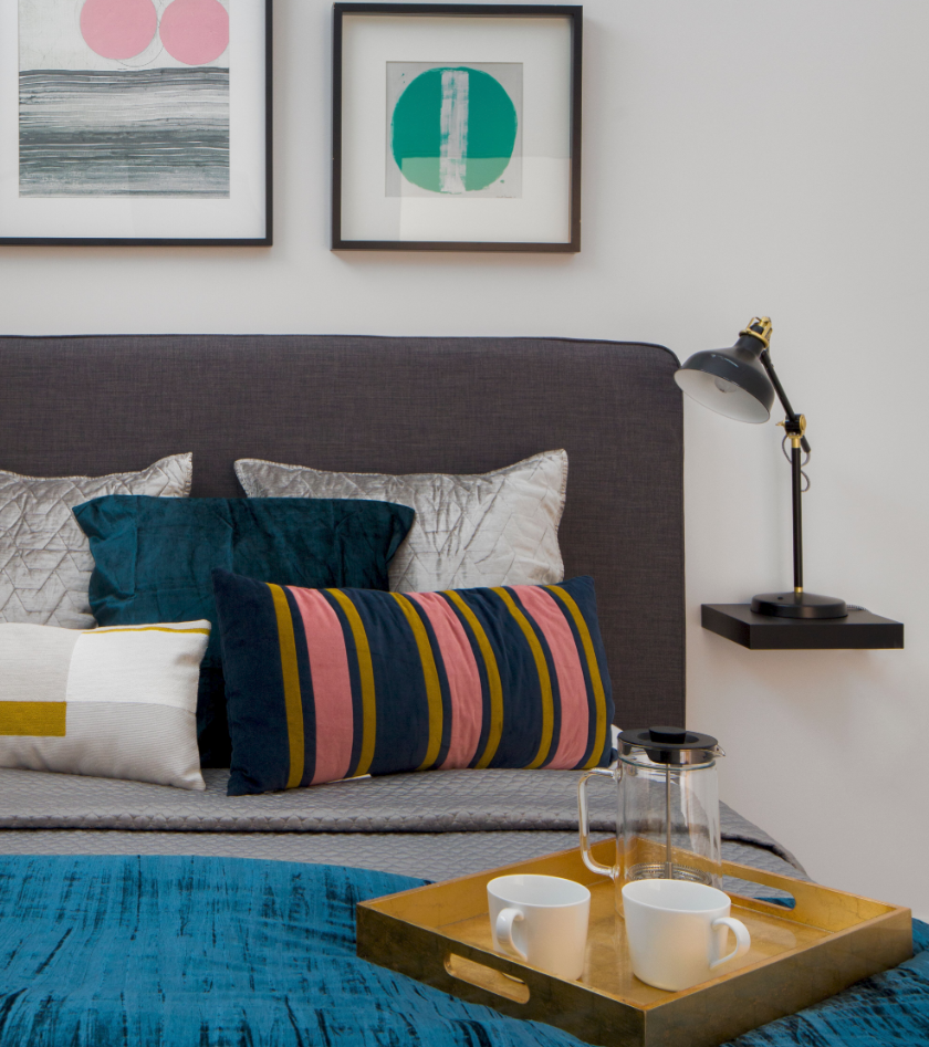 a bedroom with a bed with pillows and a tray with coffee on it
