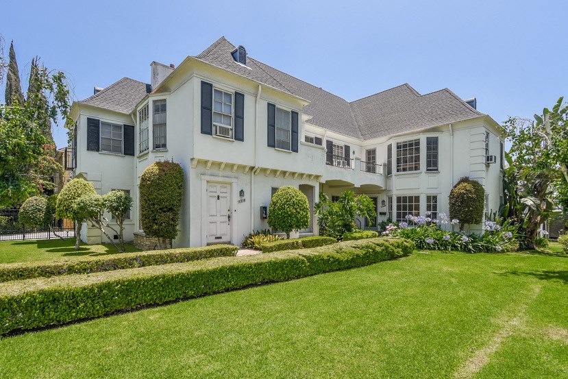 a large white house with a lawn in front of it